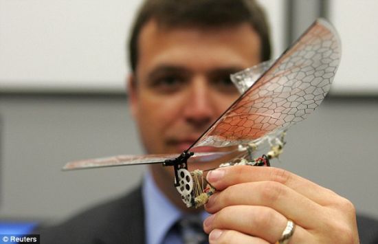 首席研究员格雷戈里·帕克博士手拿一个小型有翼无人机，外形好似一只昆虫。美国军方的目标是研制外形类似鸟类和昆虫的微型飞行器