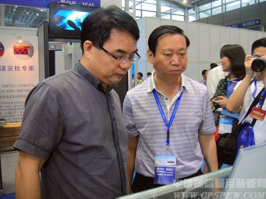 中国卫星定位协会秘书长苗前军（左）观看北斗终端设备